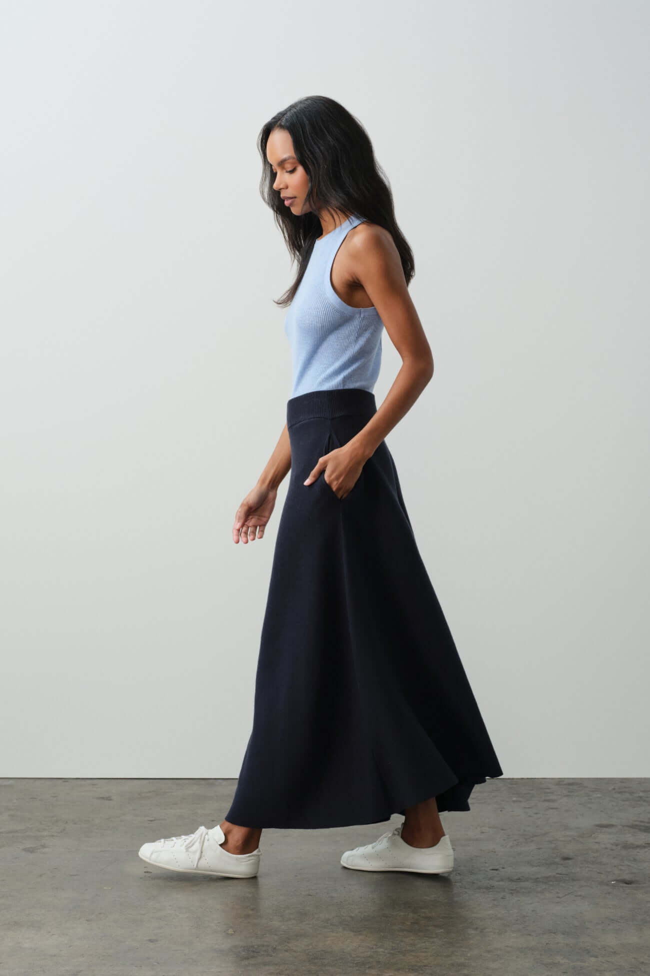 Model wearing a stylish blue top and navy skirt, showcasing the collection of Bottoms.