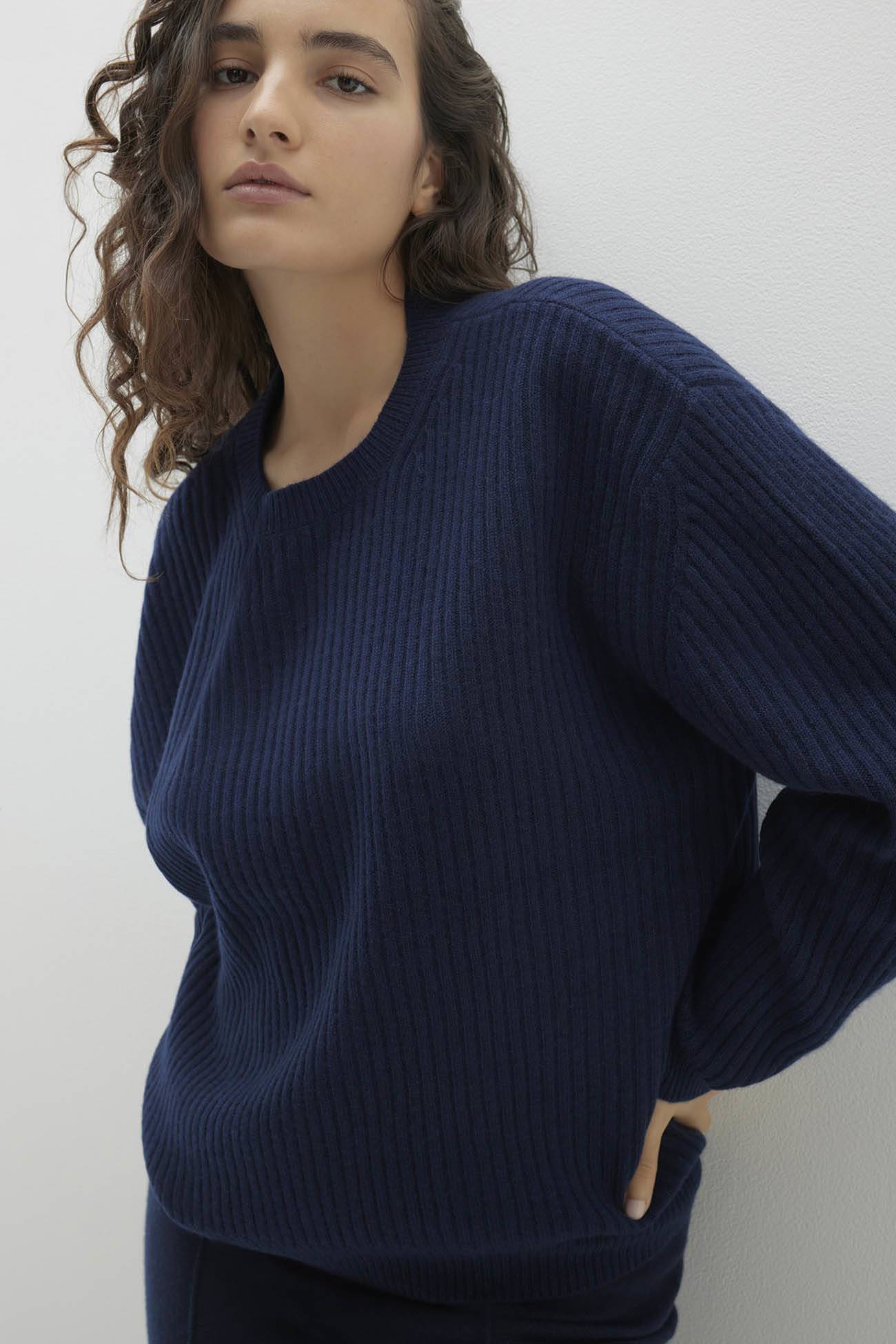 Model wearing a navy ribbed sweater from the Sweaters collection.