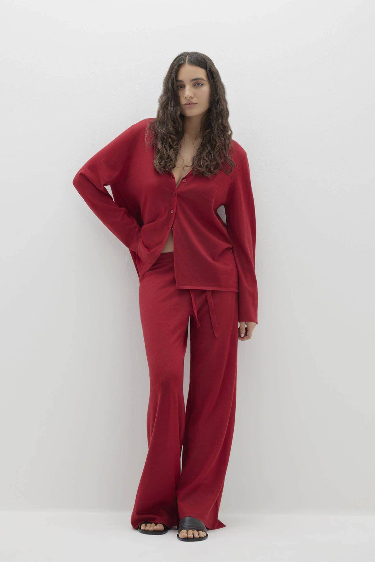 Stylish model wearing red Intimates set featuring a loose-fitting top and wide-leg pants against a minimalist background.